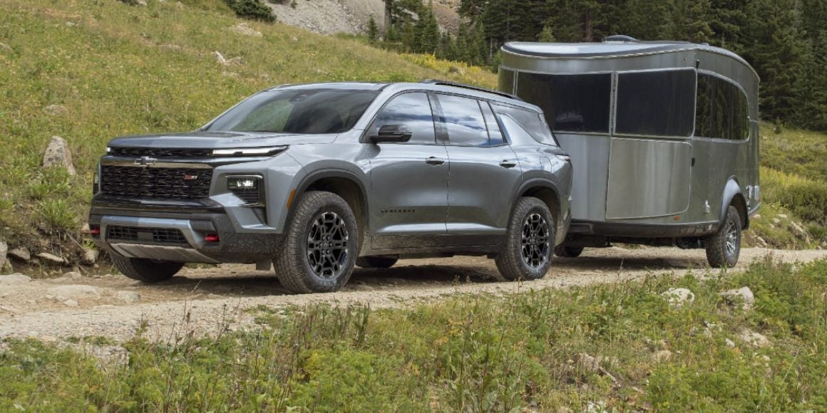 Chevrolet Traverse Z71 towing an aluminum camper trailer on a mountain trail